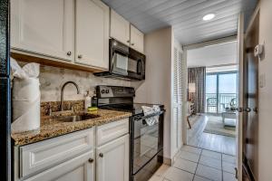 una cucina con lavello e fornello di Newly renovated Stylish Beach Condo for 6 Camelot 15th Fl a Myrtle Beach