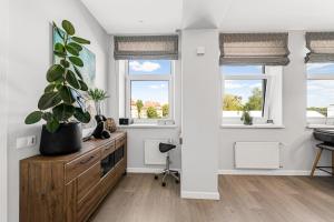 ein Wohnzimmer mit weißen Wänden und Fenstern in der Unterkunft Old town apartment Klaipėda free parking in Klaipėda