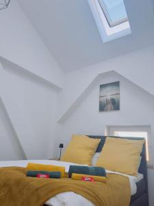 une chambre avec un lit avec des oreillers jaunes et bleus dans l'établissement Fewo für 3 Personen/Netflix/Parking/WLAN/Stilvoll, à Pöttmes