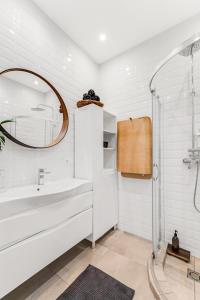 ein weißes Badezimmer mit Waschbecken und Spiegel in der Unterkunft Old town apartment Klaipėda free parking in Klaipėda