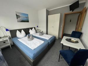 a hotel room with two beds and a table at Frühstückspension Zur Krone in Bad Endbach