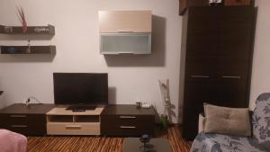 uma sala de estar com uma secretária e uma televisão em happy home em Bucareste