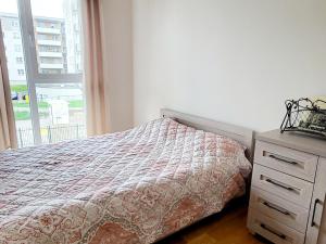 a bedroom with a bed and a dresser and a window at Mazurski Sen! in Giżycko