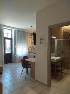 a kitchen with a sink and a table with a chair at Elaion Apartments in Kántanos