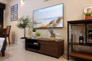 a living room with a large flat screen tv on the wall at Whitehaus Courtyards 11 E in Cagayan de Oro