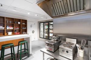 a kitchen with a stove and a counter with stools at Auberge Internationale de Quebec - HI CANADA in Quebec City