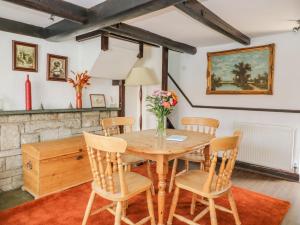 uma sala de jantar com uma mesa de madeira e cadeiras em Rhodale Cottage em Barmston