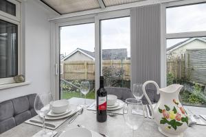 a dining table with a bottle of wine and glasses at Cenarth in Benllech