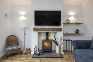 a living room with a fireplace with a tv above it at Cenarth in Benllech