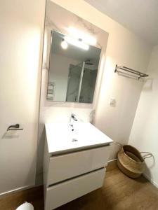 La salle de bains blanche est pourvue d'un lavabo et d'un miroir. dans l'établissement Location T2 premium 44 m2 Cala rossa à 800 m de la plage, à Lecci