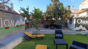 un giardino con sedie e tavoli sull'erba di Orion Guesthouse Telhado a Fundão