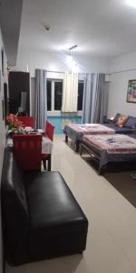 Habitación con 2 camas, silla y sofá en CP19P TWINBED COZY ROOM Near at Venice Mall, en Manila