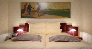 a bedroom with a bed with a painting on the wall at Hotel Mitra, Story Hotels in Ptuj