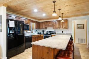 a kitchen with wooden cabinets and a black refrigerator at Fairway to Heaven on Beech in Beech Mountain