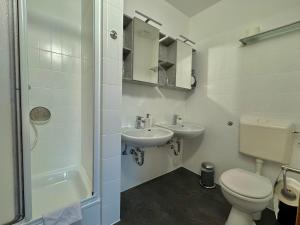 a white bathroom with a toilet and a sink at Frühstückspension Zur Krone in Bad Endbach