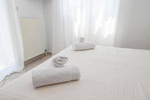 a white bedroom with two towels on a bed at Sporados house in Stení