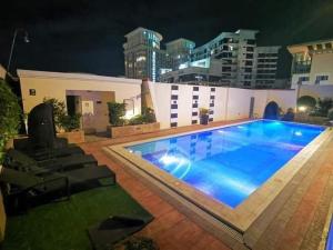 a large blue swimming pool in front of a building at CP19P TWINBED COZY ROOM Near at Venice Mall in Manila