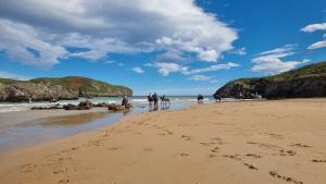 a group of people walking on the beach at Apartamento El Ático de Celorio in Celorio