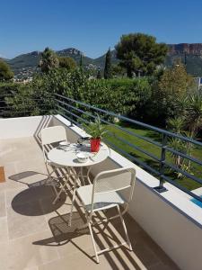 a patio with a table and chairs on a balcony at Cassis Presqu'Ile Calanques 2 pièces neuf, 50 m2 in Cassis