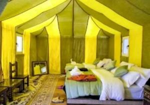 een slaapkamer met een groot bed in een tent bij Deep Desert Camp in Merzouga