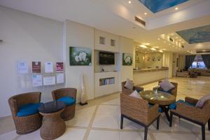 New Siesta M Hotel في العلمين: لوبي مع طاولة وكراسي وغرفة معيشة