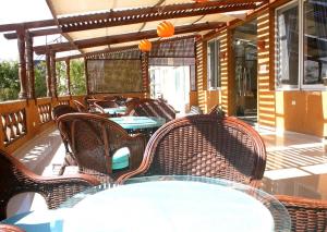 un patio con sedie e tavoli in vimini sul portico di New Siesta M Hotel a El Alamein