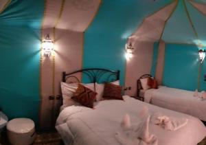 um quarto com duas camas com as mãos no ar em Deep Desert Camp em Merzouga