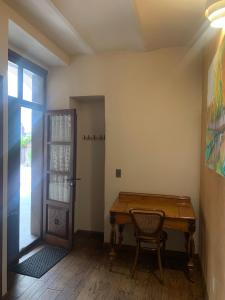 a table and a chair in a room with a door at Casa Montespejo B&B in Querétaro