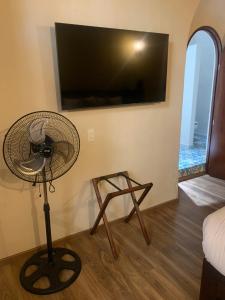 Habitación con ventilador y TV en la pared. en Casa Montespejo B&B en Querétaro