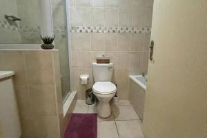 a small bathroom with a toilet and a shower at Arabella By The Sea in Port Alfred