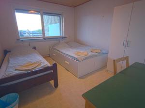 a small room with two beds and a window at The Private Quarters in Vårsta