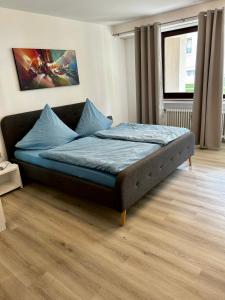 a bedroom with a bed with blue sheets and a window at Ferienwohnung 1 Wiesenweg in Bad Pyrmont