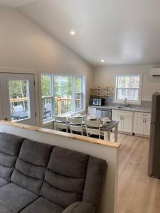 un salon avec un canapé et une table avec des chaises dans l'établissement Blue Heron Cottage Oceanfront and Private trails, à Waweig