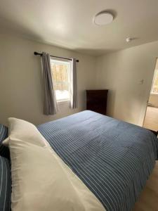 une chambre avec un lit bleu et blanc et une fenêtre dans l'établissement Blue Heron Cottage Oceanfront and Private trails, à Waweig 23 autres photos