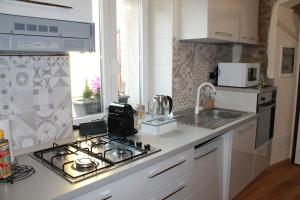 a kitchen with a stove top oven next to a sink at Charme Apartment St Tome in Almenno San Salvatore +35 photos