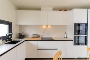 eine weiße Küche mit weißen Schränken und Geräten in der Unterkunft San José Suites 3 Hab, Piscina, solárium y WiFi in Almería + 31 Fotos