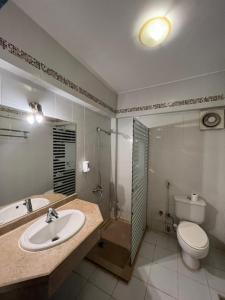 uma casa de banho com um lavatório, um WC e um chuveiro em New Siesta M Hotel em El Alamein