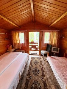 1 dormitorio con 2 camas y 1 silla en una habitación en Bungalow- casute en Orşova