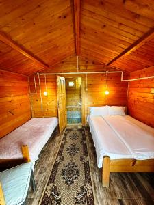 a bedroom with two beds in a wooden cabin at Bungalow- casute in Orşova
