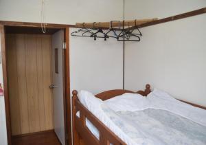 um quarto com uma cama com uma estrutura de madeira e uma porta em Guest House Minatoya Tokunoshima - Vacation STAY 01040v em Tokunoshima