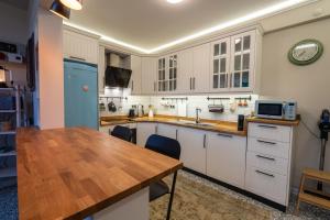 a kitchen with white cabinets and a wooden table at Cozy Home in Oldtown Kaleici in Antalya