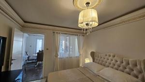 a bedroom with a bed and a chandelier at Villa MAJESTIC in Mali Lošinj