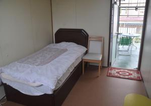 ein Schlafzimmer mit einem Bett, einem Stuhl und einem Tisch in der Unterkunft Guest House Minatoya Tokunoshima - Vacation STAY 01034v in Tokunoshima