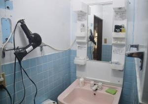 ein Badezimmer mit einem Spiegel und einem Waschbecken in der Unterkunft Guest House Minatoya Tokunoshima - Vacation STAY 01040v in Tokunoshima