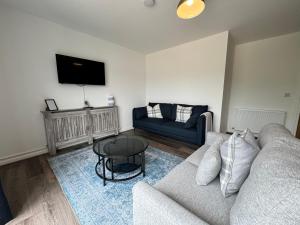 a living room with a couch and a table at Inchfad Apartment 2/1 in Bonhill