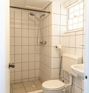 ein Bad mit einem WC und einem Waschbecken in der Unterkunft Talk of the Town Inn & Suites - St Eustatius in Oranjestad