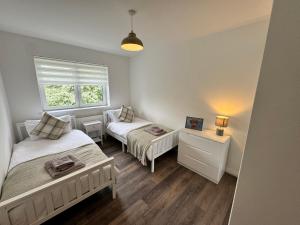 a small bedroom with two beds and a window at Inchfad Apartment 2/1 in Bonhill