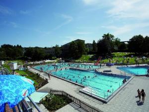 a large swimming pool with many people in it at Tidy holiday home with dishwasher, in a green area in Kopp