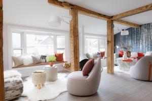 a living room with white and orange furniture at Field Guide Lodge in Stowe