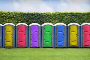 Eine Reihe von farbigen Toilettenständen auf einem Feld in der Unterkunft Pop Up Camping For Walking Distance To Luton BBC Radio 1 Big Weekend With 1 Allocated Parking Space in Luton